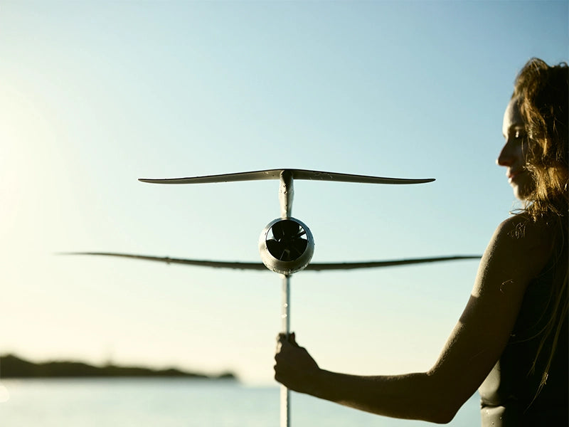 A silent Fliteboard session above clear water at golden hour